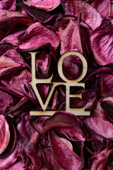 Text "LOVE" on rose petals for Valentines Day post card