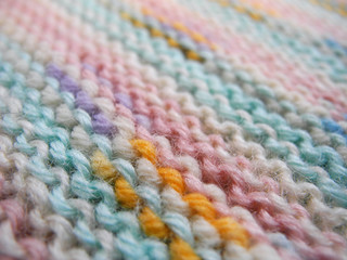 Texture of knitted fabric of motley melange wool yarn closeup