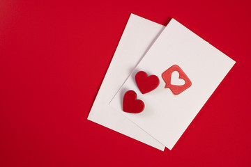 Postcard with a white envelope and hearts on a red background for Valentine's Day, wedding, birthday and other holidays, view from the top.