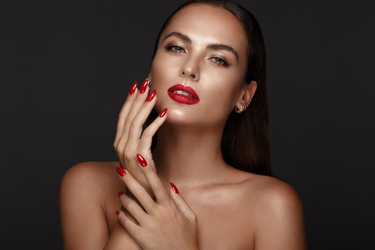 Naklejki Beautiful girl with a classic make-up and red nails. Manicure design. Beauty face.