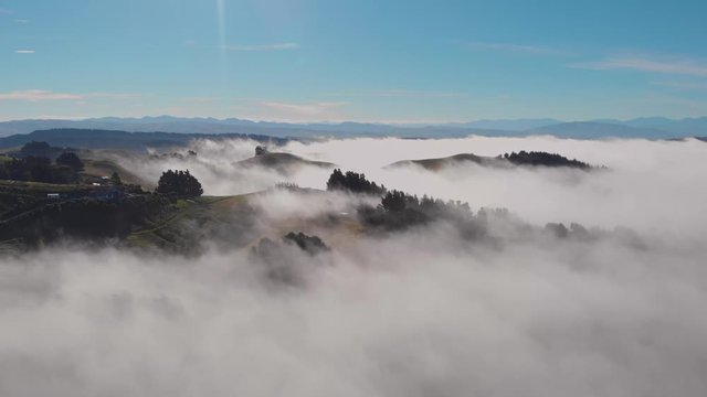 Dreamy view of rolling hills peaking above an ocean of clouds. Canterbury, South Island, New Zealand.