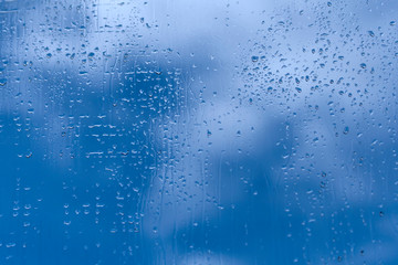Blue window glass with water drops 
