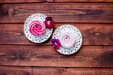 Meringue zephyr marshmallows on wooden background. Mortgage the apartment. Pink sweet homemade marshmallow. Colorful meringues, freshly prepared delicious homemade cherry and strawberry marshmallow