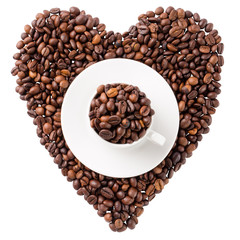 Cup with coffee beans on coffee beans in the shape of heart isolated on white background