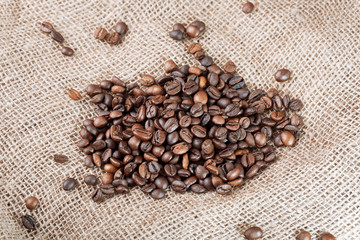 Coffee beans on sackcloth  background. Roasted coffee beans, can be used as a background