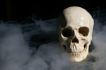 Human skull with smoke and dark background