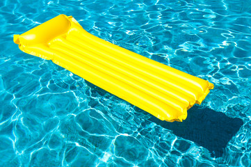 Empty inflatable raft in bright floating on blue swimming pool in bright sunlight - obrazy, fototapety, plakaty
