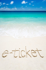 E-ticket to a vacation on a tropical beach with a handwritten message in the sand