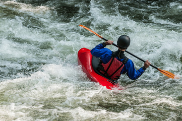 man kayaking in whitewater