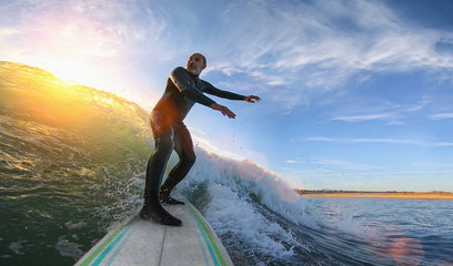 Mature senior adult surfing on a big wave in the ocean
