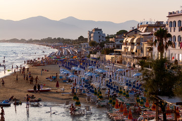 Silhouettes of people on sandy beach on sunset in Sperlonga, Lazio, italy, summer vacation