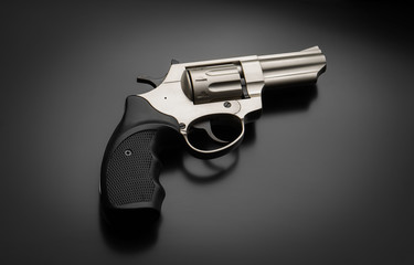 Silver pistol revolver on a black background. Low key photography. Weapon concept. Background for...