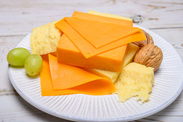 Cheese collection, blocks and slices of yellow and matured english cheddar cheese