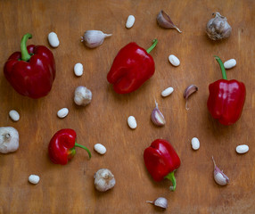 Flatlay with red pepper, heads of garlic and white beans on a kitchen board