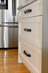Mission style white kitchen cabinets with dark metal handles