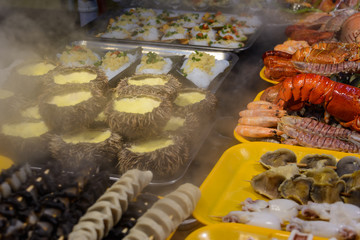 Chinese street food. Street trading. Chinese kinds of fresh seafood at an asian seafood market in Sanya, Hainan province, China. Inscription: name food.