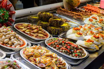 Chinese street food. Street trading. Chinese kinds of fresh seafood at an asian seafood market in Sanya, Hainan province, China. Inscription: name food.