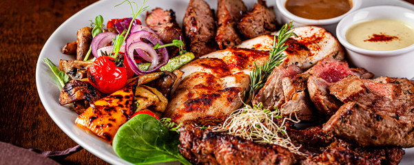 Turkish cuisine. Assorted different meat on the grill, lamb, chicken, pork with grilled vegetables....