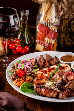 Turkish cuisine. Assorted different meat on the grill, lamb, chicken, pork with grilled vegetables. Serving dishes in a restaurant on a white plate. background image, copy space