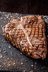 American cuisine. Juicy grilled T-Bone steak grilled with spices and salt. Close-up. background image, copy space