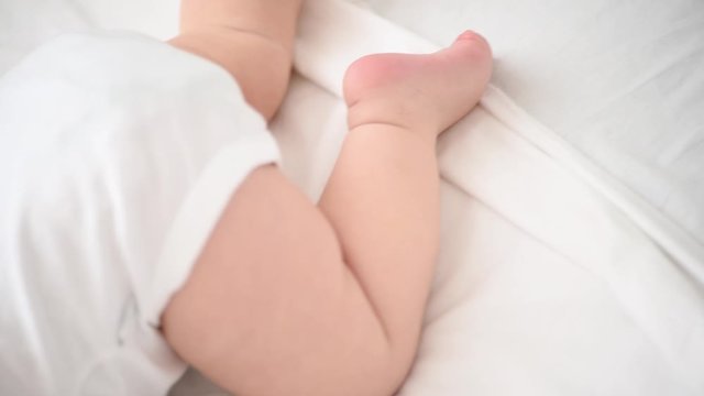 Newborn baby legs in bed