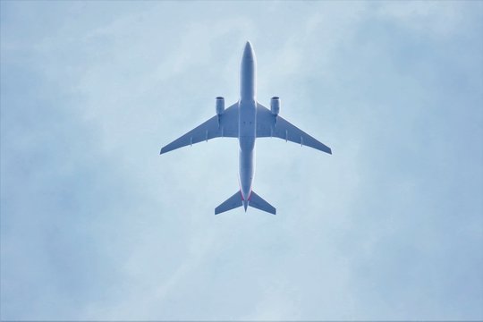 Airplane Flying Over Blue Sky With White Clouds