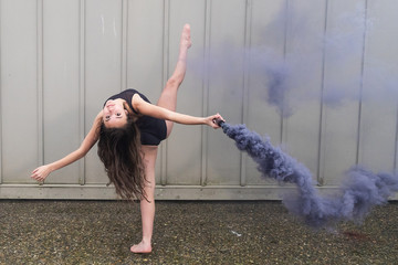 Teenage ballet dancer with colorful smoke bomb