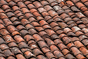 Old vintage red ceramic roof tiles closeup as background
