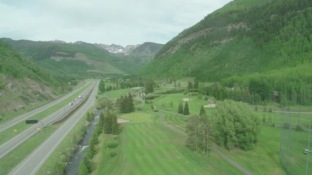 Vail Valley Summer Golf Course Aerial Zoom In To Mountains With River And Highway Inspire 2 ProRes 422 HQ. Parallel To Highway. Medium Angle.