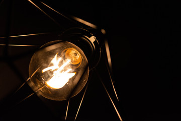 Closeup of vintage style light bulb in decorative lamp shade. 