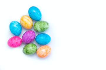 Fototapeta na wymiar Multi-colored eggs on a white background. Orange, blue, green and pink eggs. Easter.