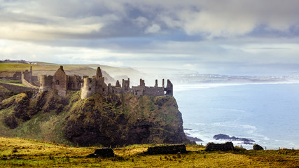 Ruined medieval Dunluce Castle on the cliff dramatic sky. Part of Wild Atlantic Way, Bushmills,...