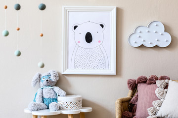Stylish scandinavian nursery interior with mock up photo frame, teddy bear, design furniture, pillows and accessories. Beautiful decoration on the beige background wall. Home decor for children room.