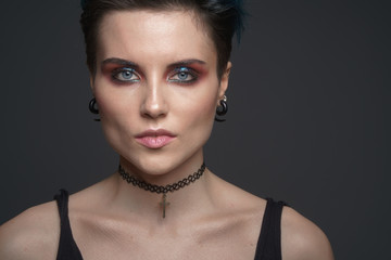 Studio portrait of a beautiful girl with blue hair and a fashion make-up in a little black dress. Fashion style