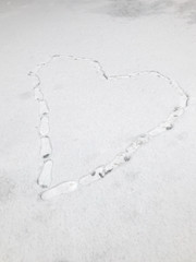 Footprints in the snow on the pavement. Heart shaped footprints in snow on the pavement