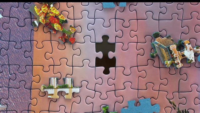 Close up view of person filling hole with missing puzzle pieces. Overhead view