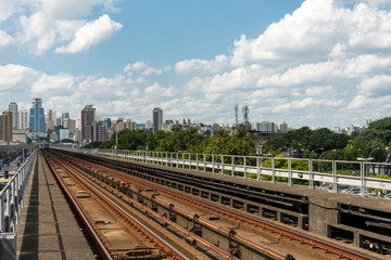Fototapeta premium Urban train rail in Sao Paulo, Brazil, with buildings at the backside. Urban train rail, with buildings at the backside.