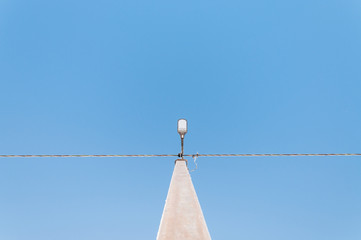 Electric pole on blue sky background during sunrise.