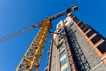 Fototapeta premium Construction of a new residential building on blue sky background during sunrise.