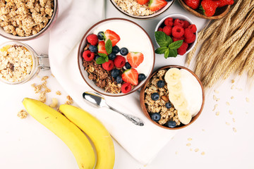 Tasty homemade granola served on table. Healthy breakfast with a bowl of oatmeal with banana, blueberries, strawberries and healthy food for Breakfast