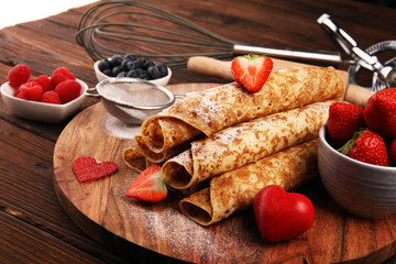 Delicious Tasty Homemade crepes or pancakes with raspberries and mint on rustic background