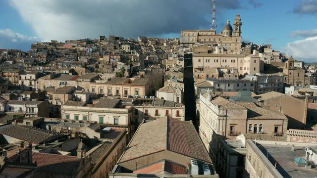 flying backwards in town of Caltagirone revealing San Giuliano church