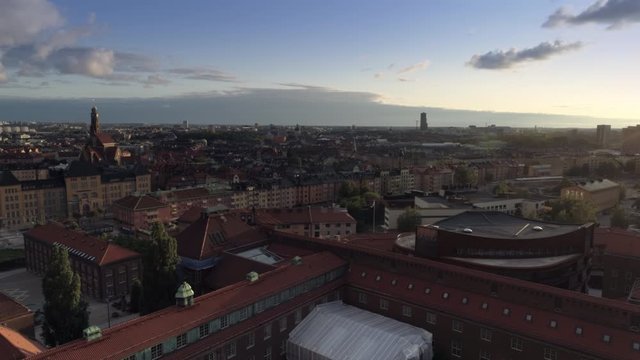 Drone shot flying over KTH Royal Institute of Technology in Stockholm, Sweden. Aerial view of Stockholm city skyline at sunset