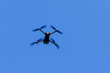 Flying drone on clear blue sky
