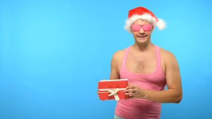 Obraz premium Playful handsome man in a pink T-shirt with fashionable stylish New Year's accessories, in fashionable pink glasses, Merry Christmas and Happy New Year