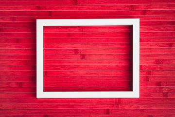 Empty white photo frame on old red wine wooden table for background texture