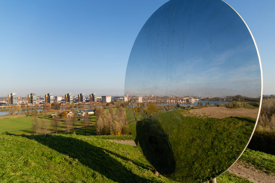 skyline of Carnisselande Barendrecht taken from &acirc;&euro;&oelig;Gaatkensbult&acirc;&euro; and also seen in the reflection of the big round mirror on top. Taken on a sunny day in the morning with a blue sky.