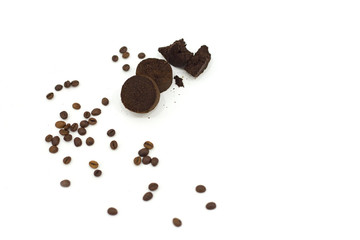 Compressed ground coffee from a coffee machine and coffee beans on a white background