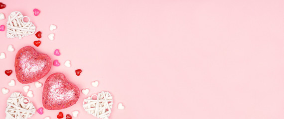 Valentines Day banner with corner border of pink and white heart decorations against a pink background. Copy space.