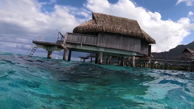 Underwater shot. Overwater bungalow villas, turquoise lagoon. Moorea, Tahiti French Polynesia. Luxury honeymoon vacation, romantic getaway, exotic resort destination.  